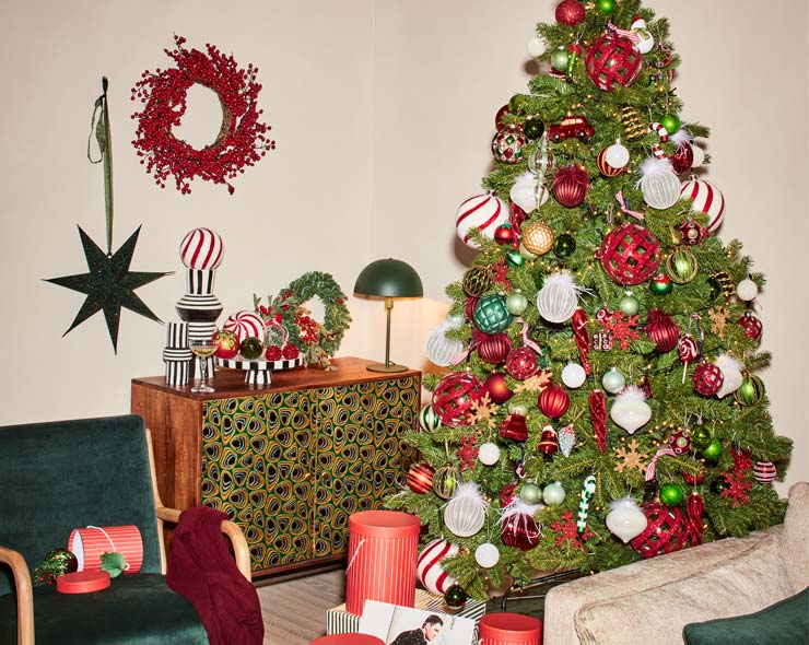 Huiskamer ingericht in kerstsfeer met druk versierde kerstboom
